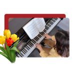From above, a person in a yellow shirt playing piano, with yellow and red flowers over the left side of the image.