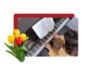 From above, a person in a yellow shirt playing piano, with yellow and red flowers over the left side of the image.